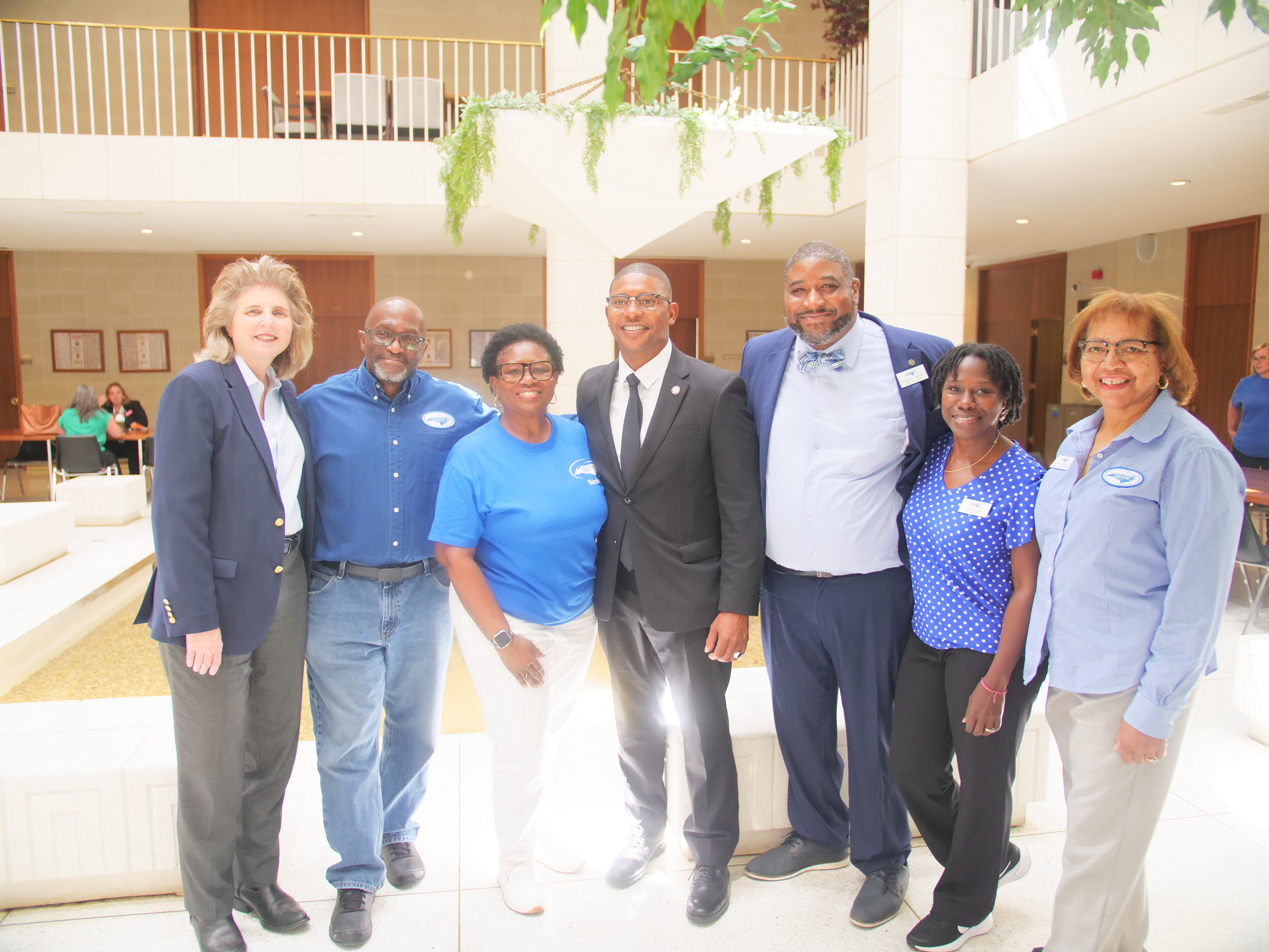 SEANC members and leadership pose with a legislator inside the Legislative Building atrium